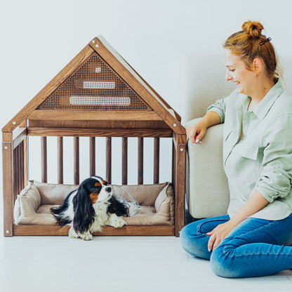 A wooden dog cage house with a built-in cozy design, featuring a natural wood finish and slatted sides for ventilation. Inside, a soft, plush pillow provides comfort, creating a snug and stylish retreat for the dog. The setup is placed near a happy owner, enjoying a peaceful moment with their pet.