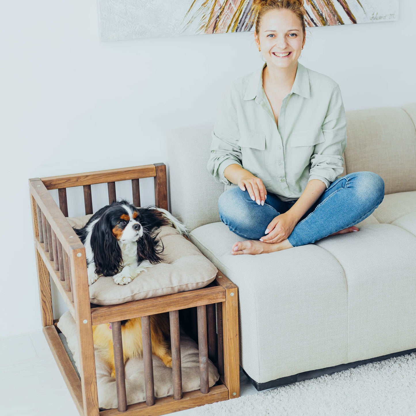 A sleek dog bed platform placed next to a couch, offering a comfortable and accessible resting spot for your pet